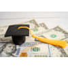 Small graduation cap on U.S. dollars