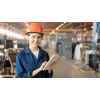 Woman standing in a warehouse with a hardhat