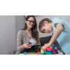 Woman helping child build with toys