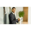 young business professional standing in an office holding a tablet