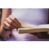 Woman about to turn the page of a book she's reading