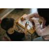 Woman coloring a sheet of paper with her young student