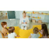 Woman holding a letter flashcard to her kindergarten class