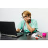 Female nurse with a stethoscope around her neck, browsing through her laptop at work