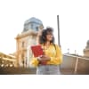 Young woman holding books and binders will going down the school steps