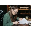 Young woman signing a printed letter
