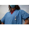 Woman wearing nursing scrubs and wearing a face mask