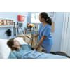 Female nurse checking a patient's blood pressure while she's lying down a hospital bed