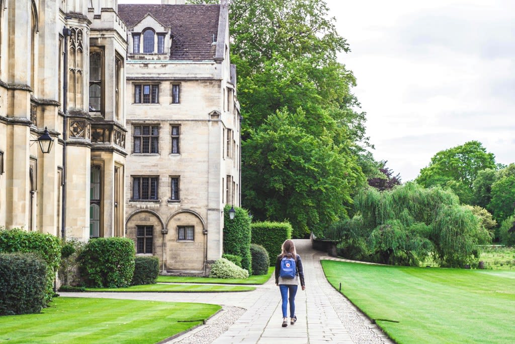 Student walking on a concrete path of a school campus