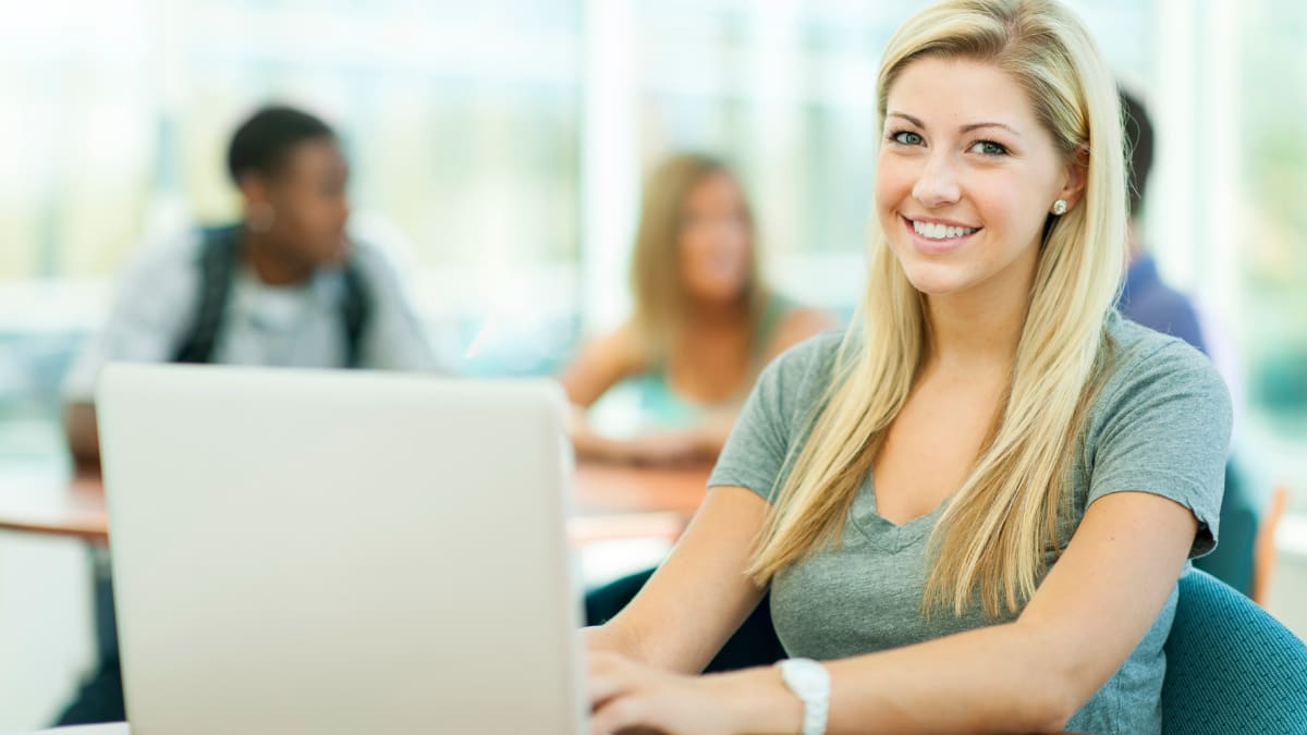 Smiling female student on laptop