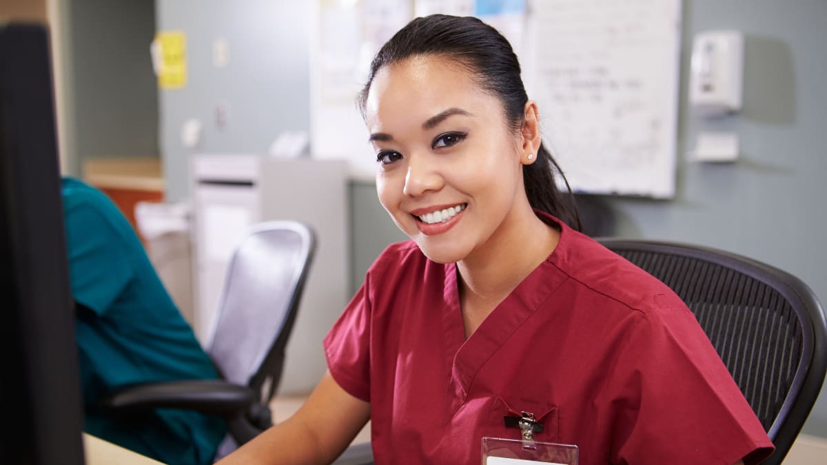 Female nurse smiling at a desk