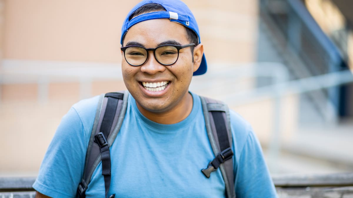 Smiling man with glasses and backwards hat