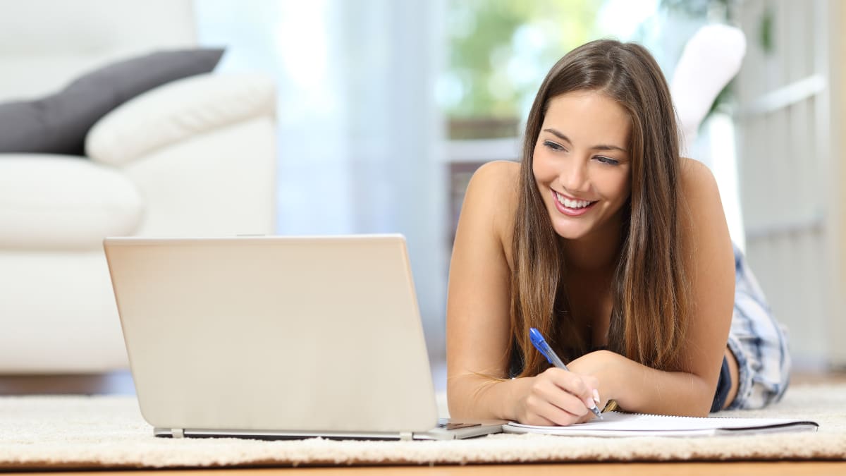 Female student working on her computer in a living room