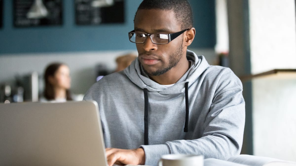 Male student focusing on a laptop