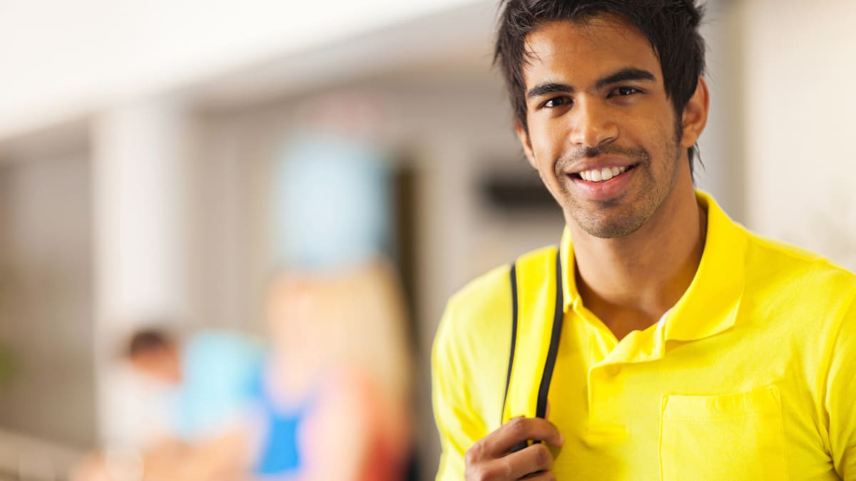 Happy male student in a yellow shirt