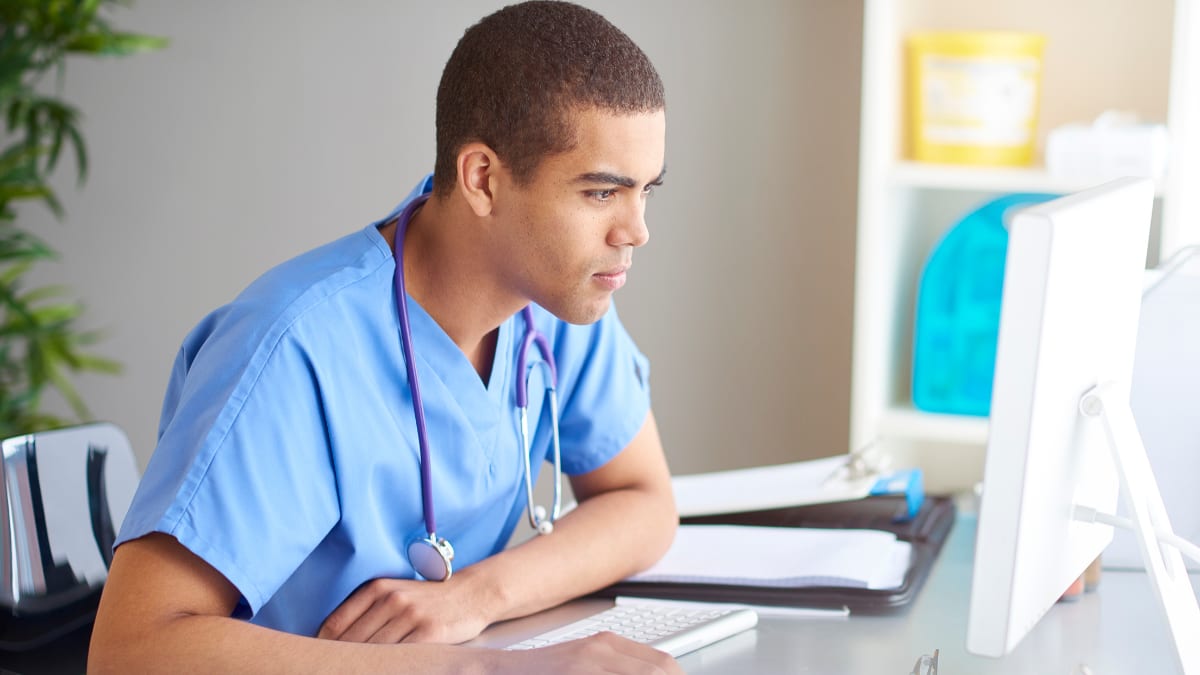 Male nurse researching on a computer