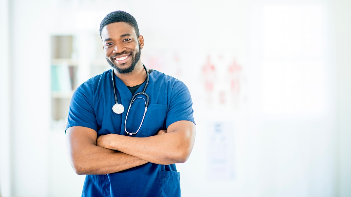 Male nurse smiling with arms folded