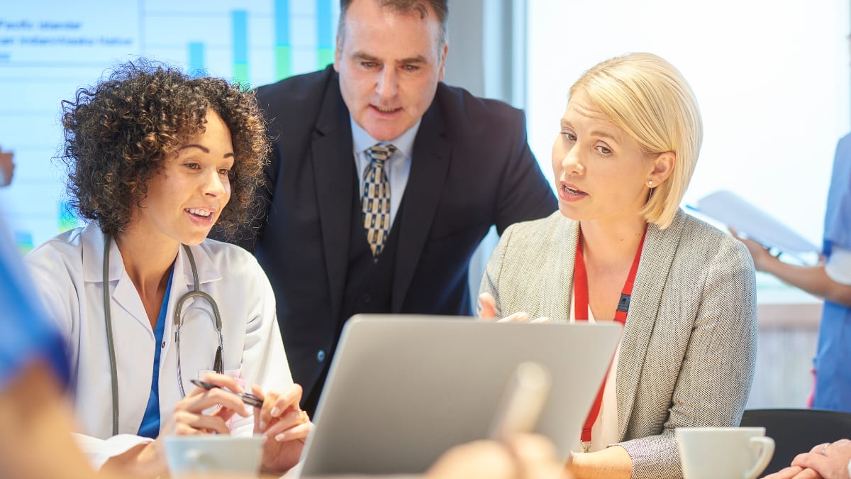 Healthcare professional meeting next to a laptop