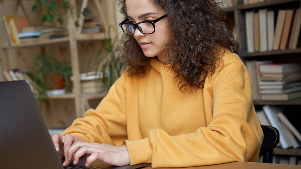 Female student in yellow sweater studying
