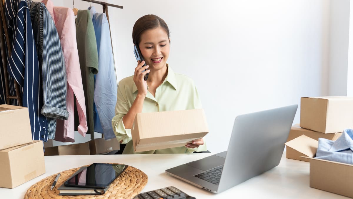 Smiling woman on the phone holding a box