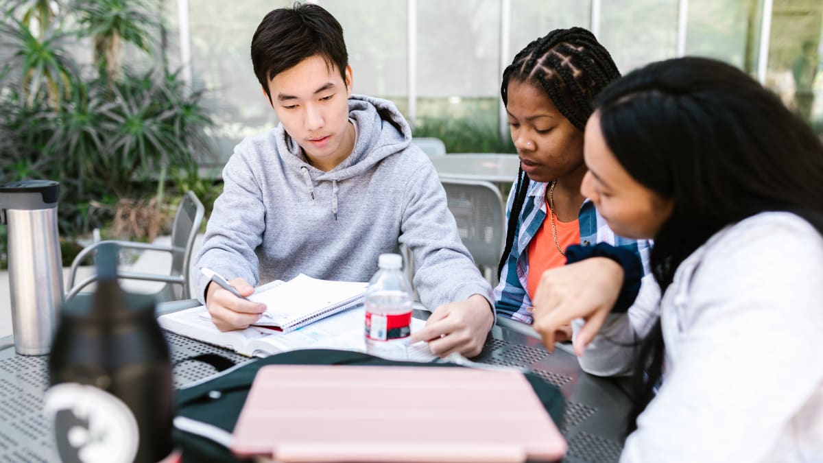 Three students working on their MBA outside