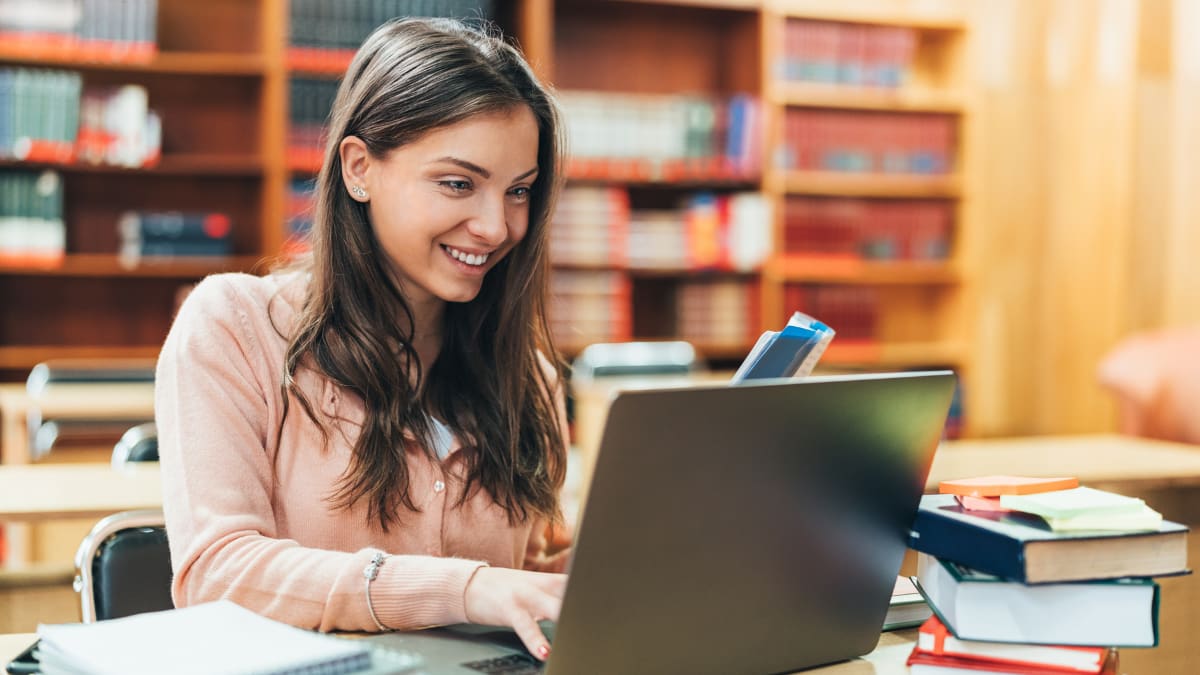 Female studing smiling and studying in the library