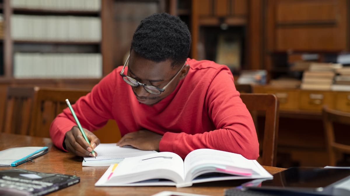 Man with glasses studying in a library