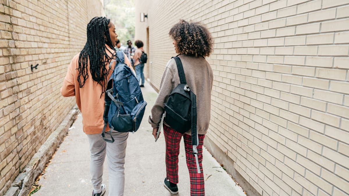 Two students walking down an alley