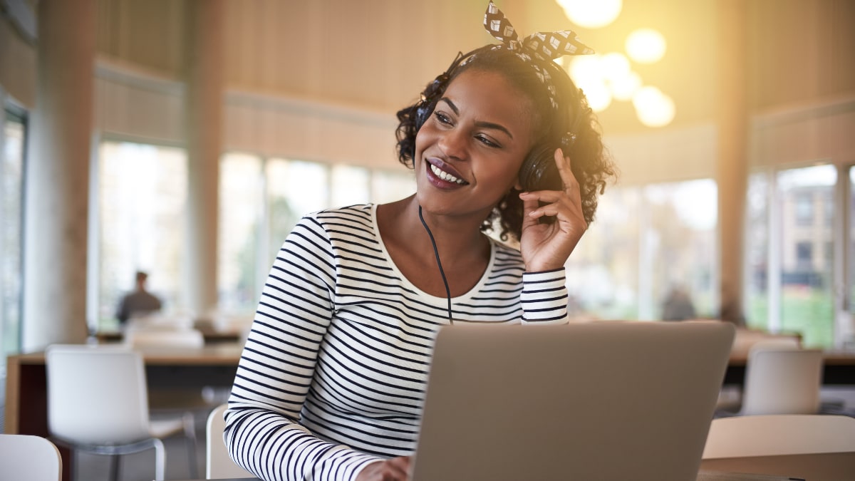 A woman with headphones on a laptop