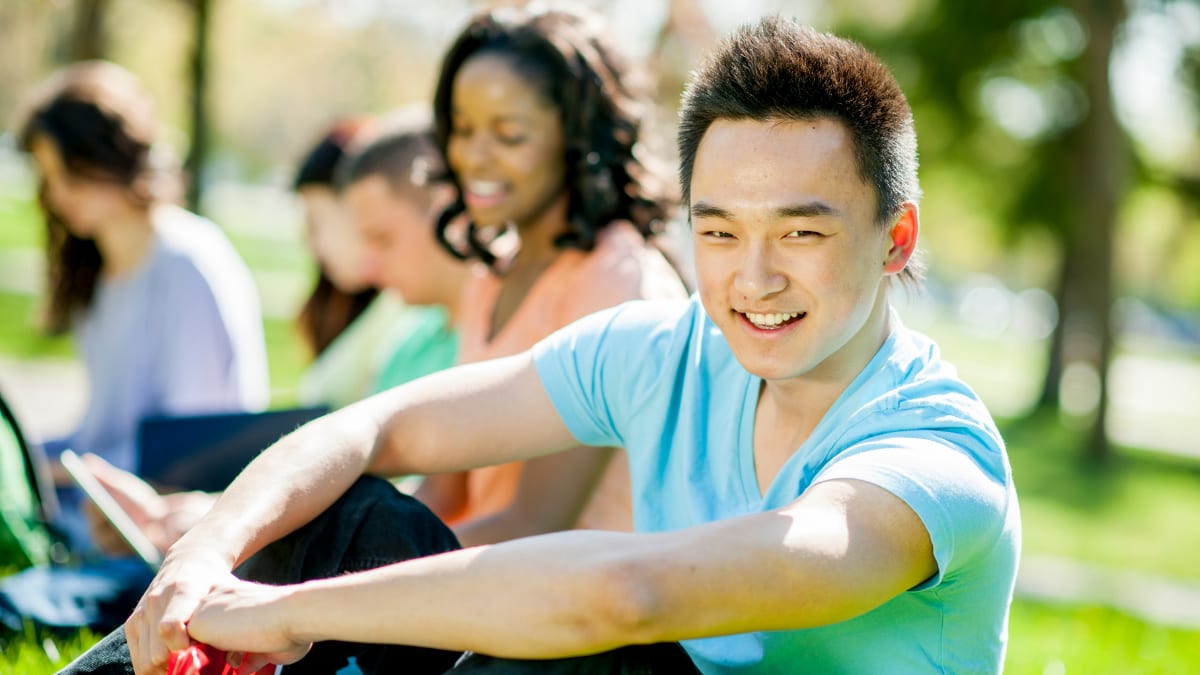 Students smiling in a park