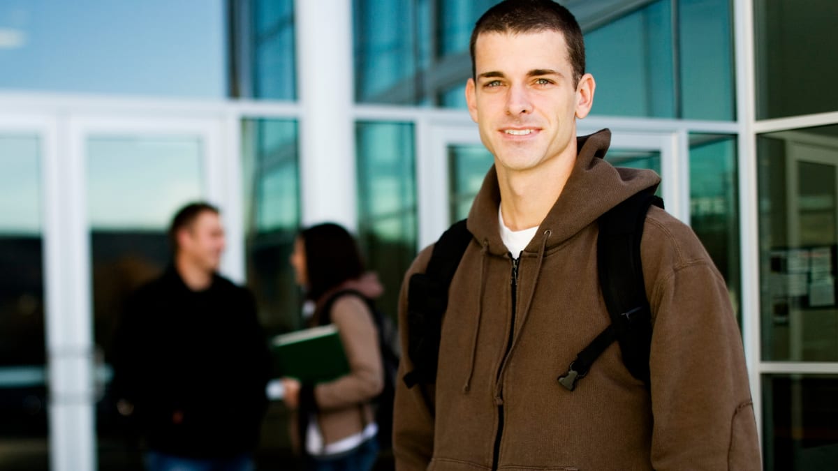 Male student standing outside a building