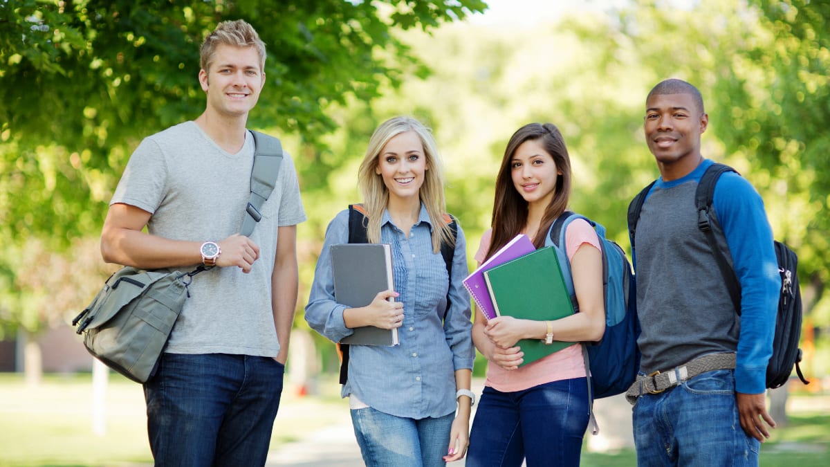 Happy students with notebooks outside