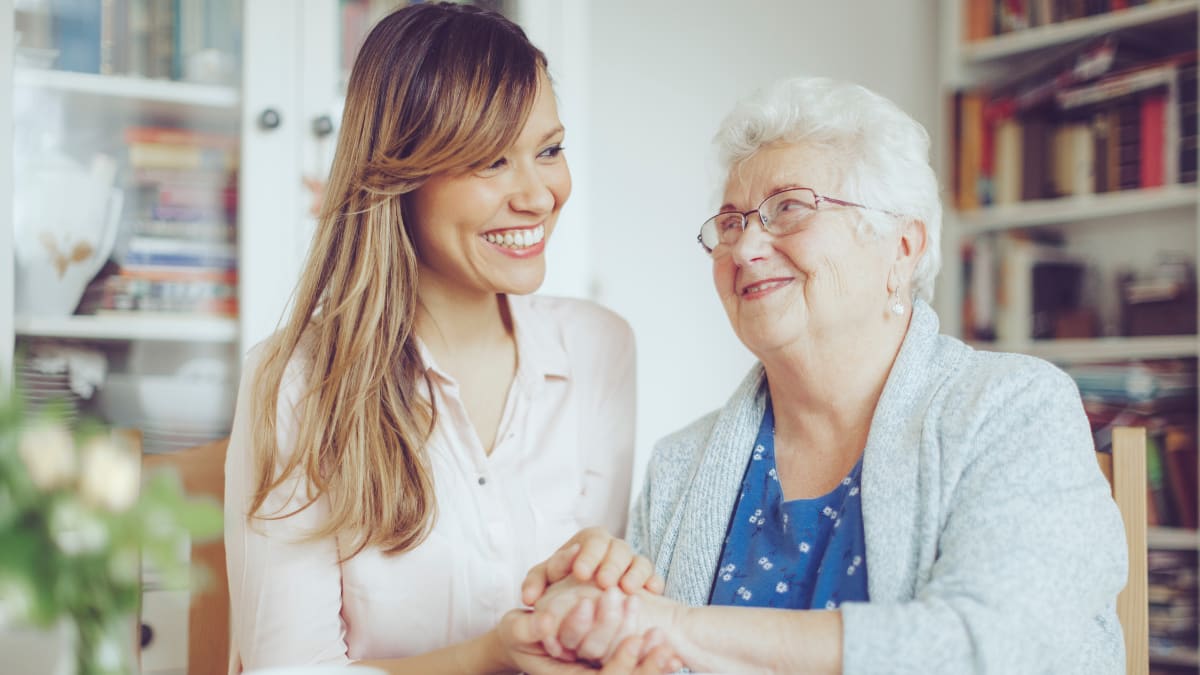 Social worker smiling at old woman