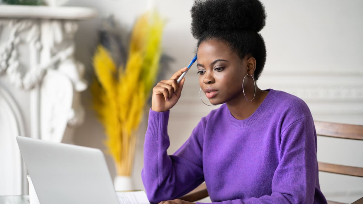 Woman in purple reading on a computer