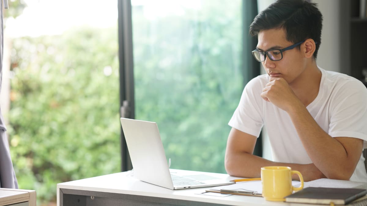 Man reading on a computer with glasses