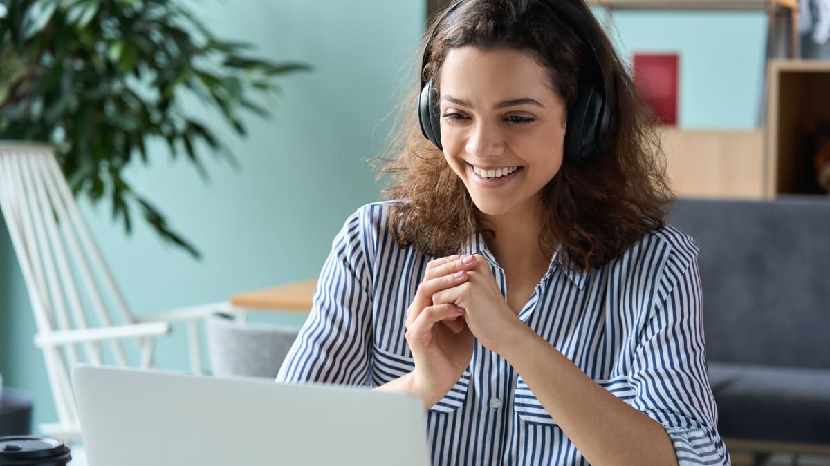 Male student smiling and holding a laptop