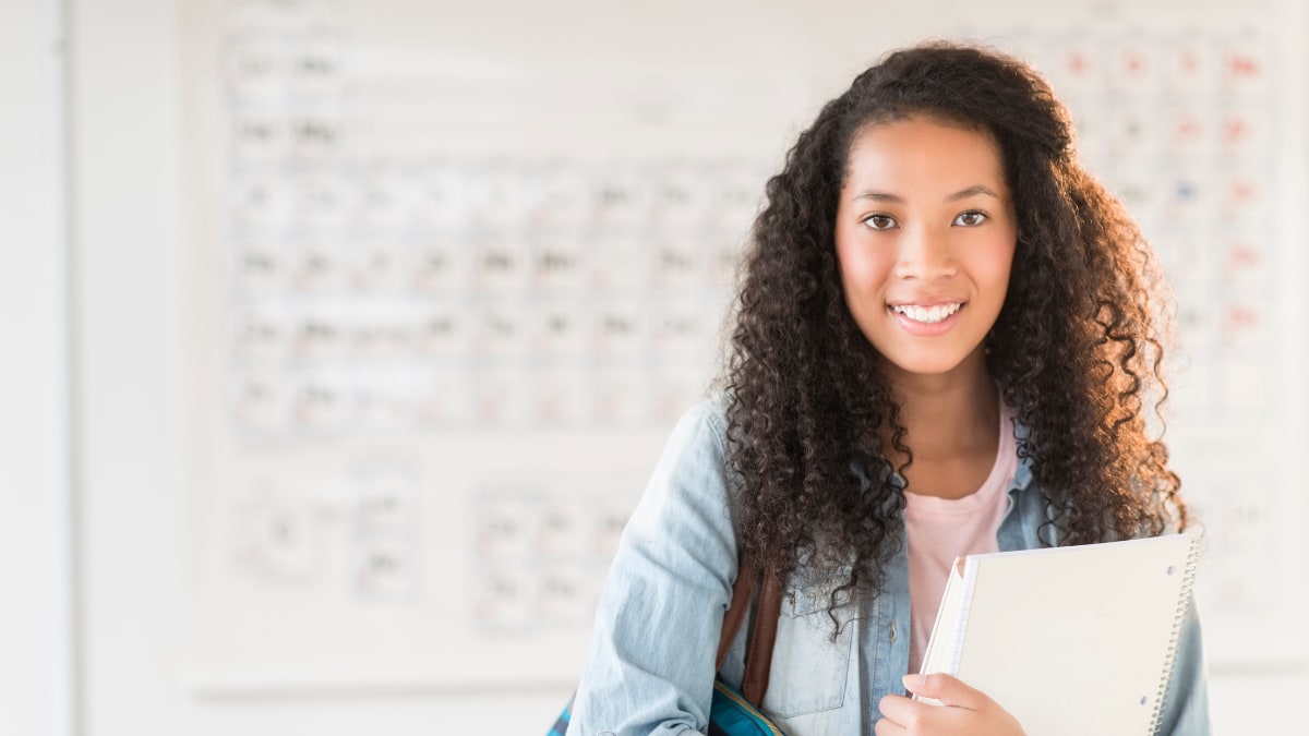 Female black student smiling with notebook