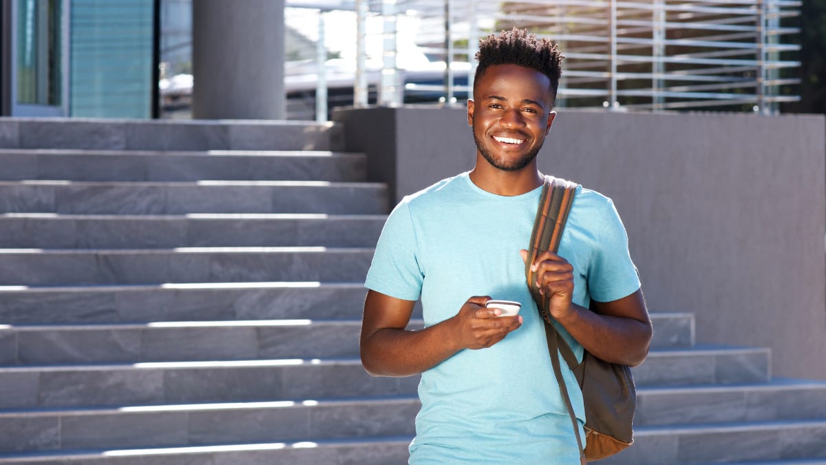 Black student smiling with mobile phone