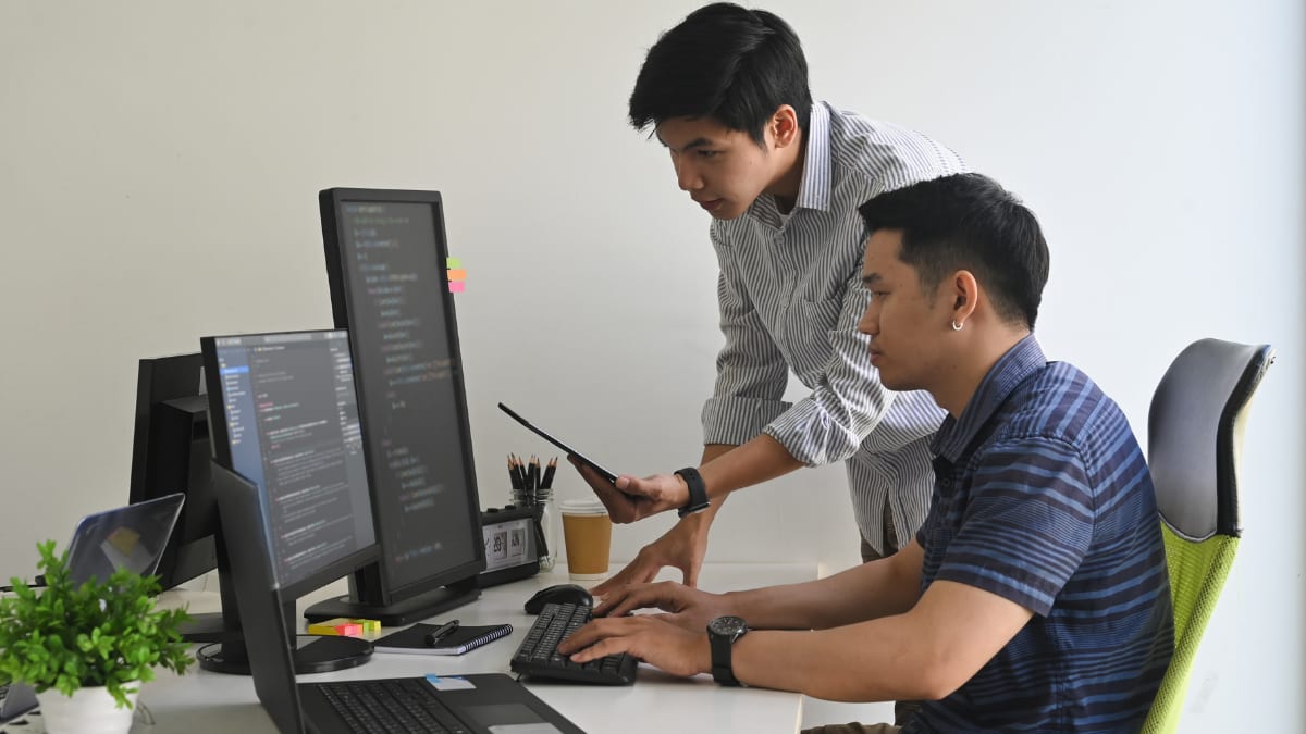 Two men writing code