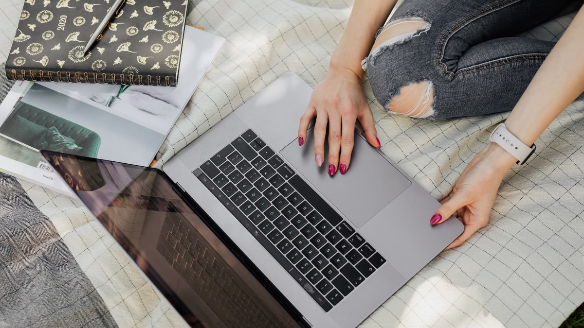 Female student working a laptop on a bed