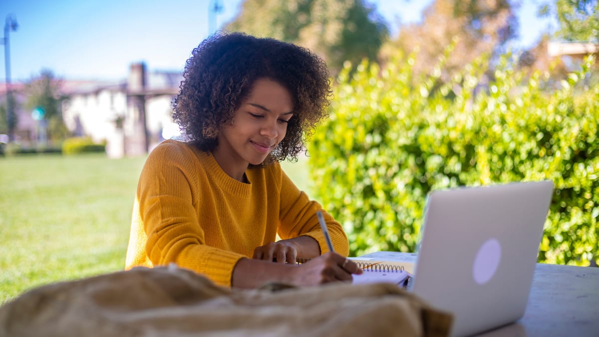 Female student working outside on a laptop