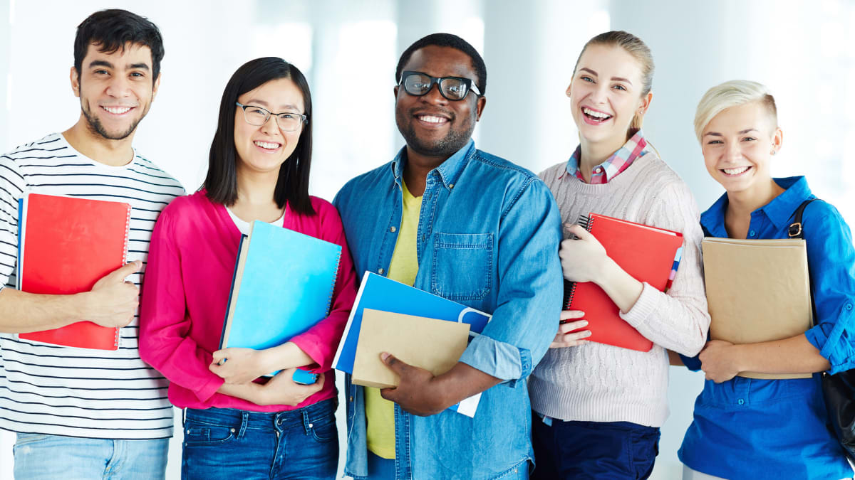 Happy students holding notebooks