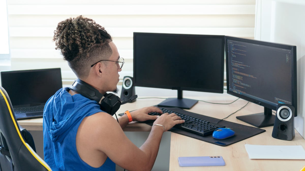 Man in blue tank top coding