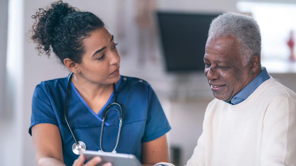 Nurse helping an older gentleman