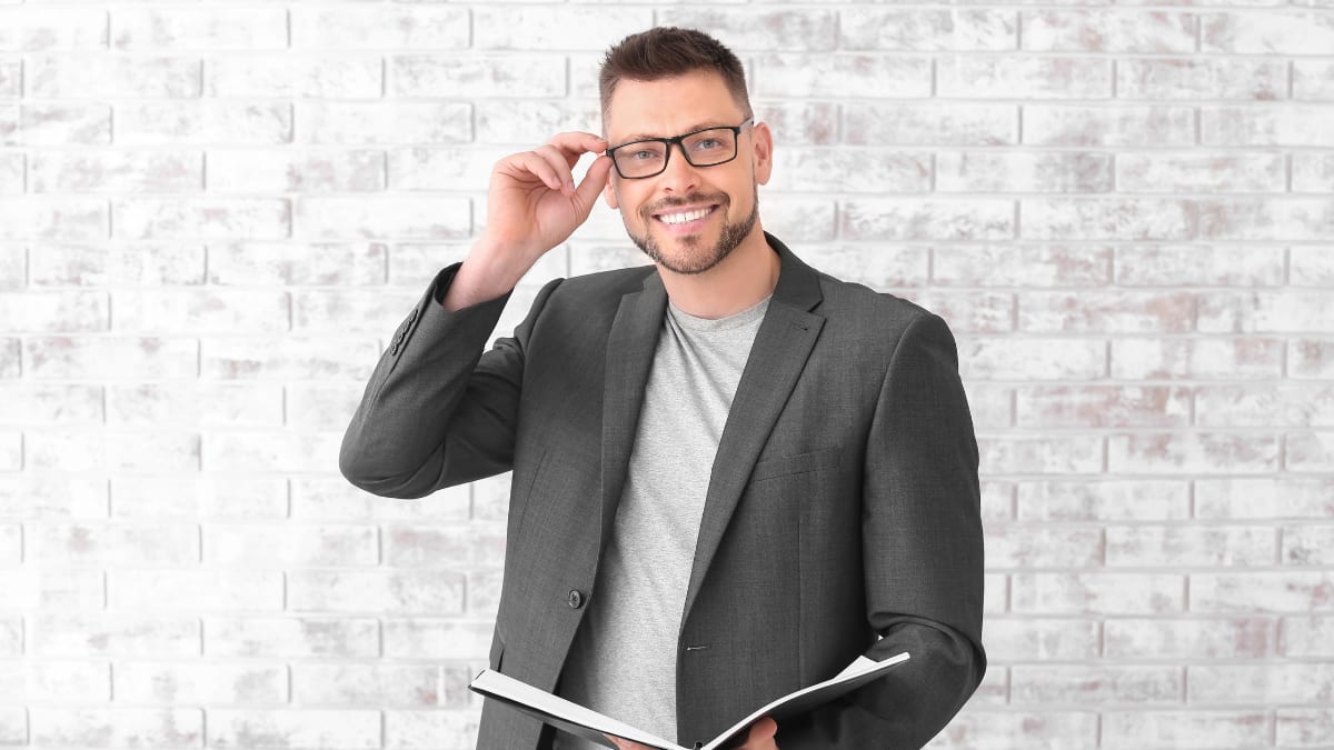 Teacher smiling and fixing his classes