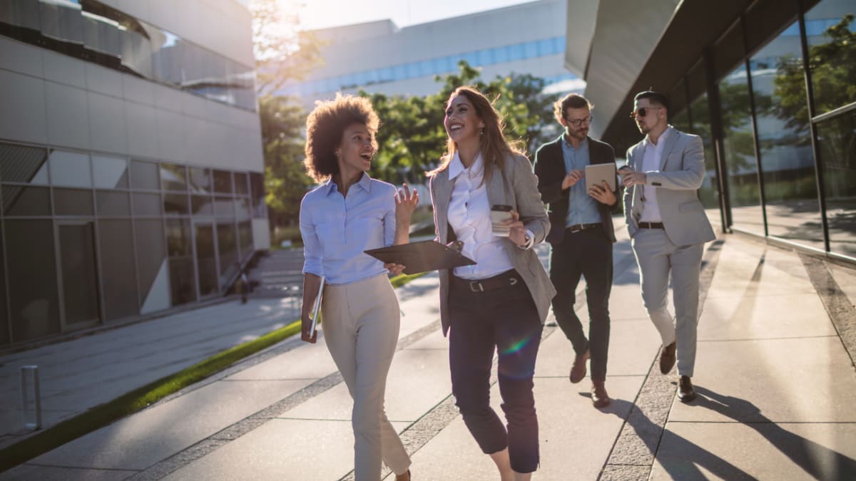 Four people walking and discussing business