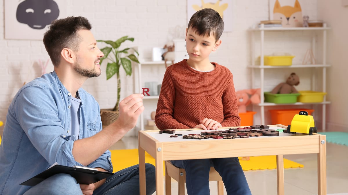 Male psychologist speaking to a child