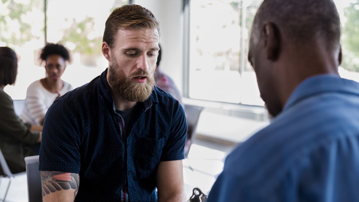 Bearded patient speaking to a male psychologist