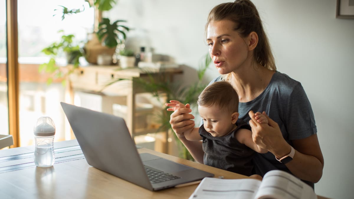 Woman studying with a baby on her lap