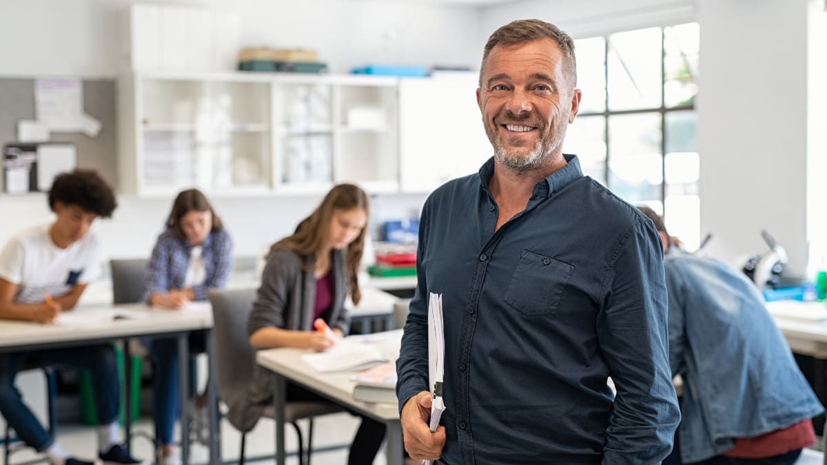 Male teacher smiling in front of students